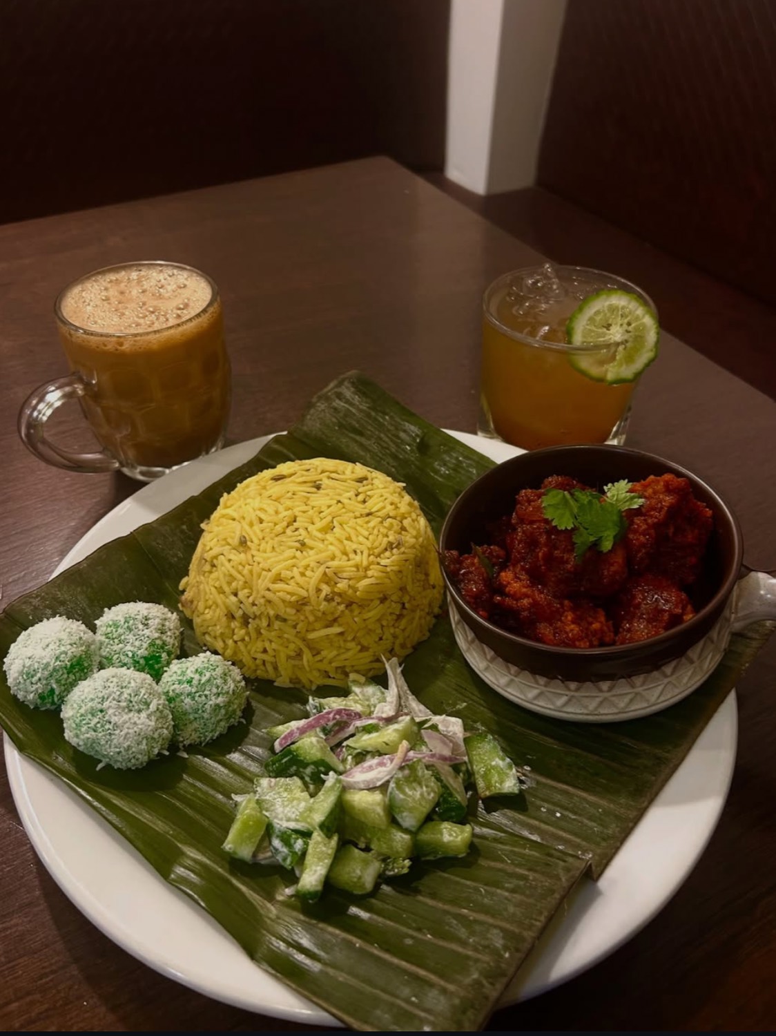 Nasi lemak on banana leaf with teh tarik and a citrus cooler